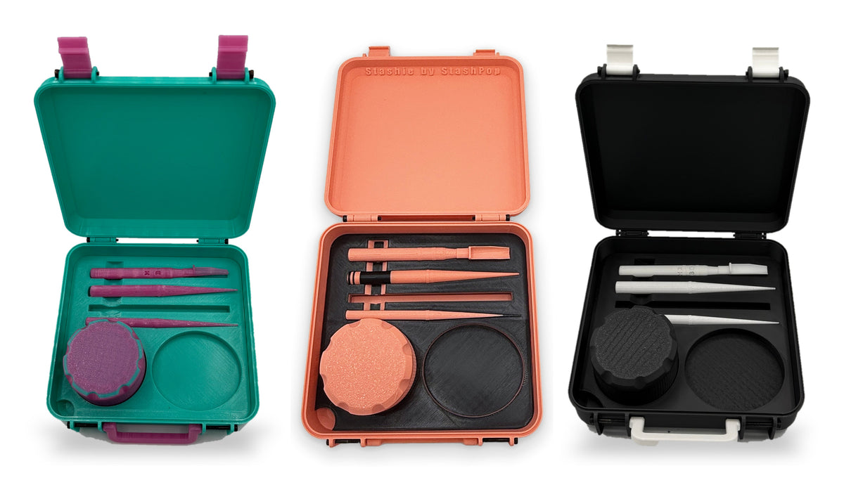Three STASHIE kits open side by side in teal, coral and black, each with tools, a stash container and a tray in the Classic insert
